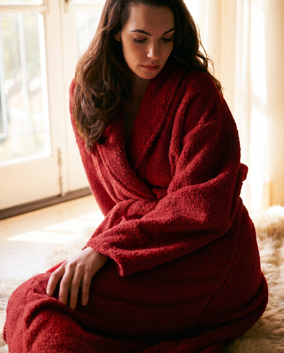 Woman curled up in a cranberry Plush Signature Robe